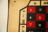 Close-up of vintage wooden roulette board, hand-painted red and black numbers on aged wood.