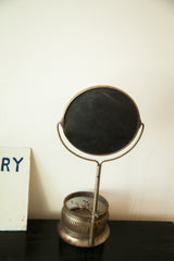 Vintage shaving mirror's ribbed metal stand base with open brush holder.