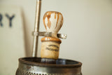 Vintage Sana-genic shaving brush, worn cream and brown handle, in metal stand.