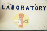 Painted fist and beaker graphic with 'Science for the People' motto on vintage sign.