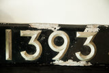 Art Deco British license plate, black with silver raised numbers 1393, chipped paint.