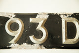 Art Deco numbers 93D on distressed black and silver vintage British license plate.