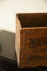 Frederick Stearns vintage wooden crate showing dovetail joint and partial black text.