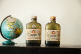 Two antique 1913 Pernod Fils absinthe bottles, aged dark green glass with detailed labels.