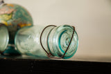 Clear antique Beaver mason jar opening and rusted wire closure mechanism.