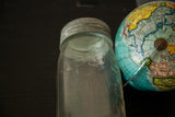 Clear antique Beaver mason jar with raised details and original metal lid.