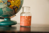 Antique poison bottle with orange label featuring skull and 'Sulphate of Morphine'.