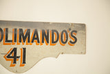 Vintage Deco house sign's curved edge, black and orange 'ANDOS 41' on aged ivory.