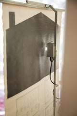 Faint Snellen E-letters on vintage Massachusetts eye chart with metal apparatus stand.