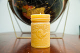 Yellow beeswax candle with embossed Jumbo Peanut Butter elephant and vintage jar text.