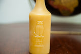 Embossed owl design and 'TRADE MARK' text on antique bottle beeswax candle.