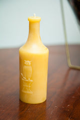 Embossed owl motif and 'Owl Drug' text detail on a golden beeswax bottle candle.