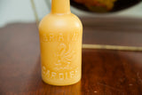 Beeswax candle shaped like a vintage bottle with embossed dragon, Brain, and Cardiff text.