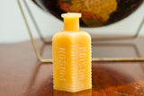 Yellow beeswax antique poison bottle candle with ribbed sides and 