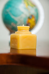 Side view of yellow beeswax inkwell candle with 