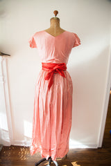 Back of vintage 1950s Claire McCardell peach wrap dress with red sash bow.