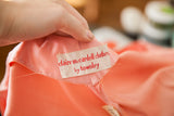 Close-up of the cream Townley label with red text on the peach Claire McCardell dress.