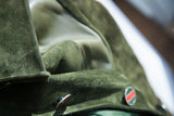Fine enamel buttons with red and navy stripes on the textured forest green suede of a Gucci coat.