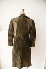 Rear view of Gucci suede coat with contrasting leather panels and striped red cuff detail.