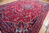 Vintage Persian Bijar rug edge with cherry red field and intricate blue, ivory floral border.