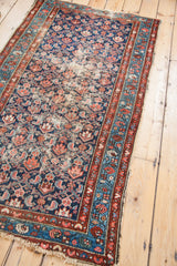 Worn Hamadan rug corner, featuring distressed herati pattern, indigo, sky blue, and brick red.