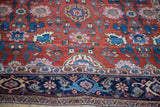 Corner detail of an antique Persian Bijar rug, highlighting the dark blue border against the red Harshang pattern field.