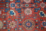 Intricate harshang motifs in shades of blue and pink on a dense red antique Bijar rug.