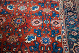 Antique Persian Bijar rug showing the rust-red harshang design field next to the intricate navy border.
