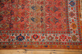Vibrant orange and blue tribal motifs with a geometric medallion border on this antique Malayer rug.