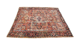 Vintage worn Heriz rug with a bold central medallion and rich aged red and blue patterns.