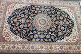 Ornate ivory and pale blue central medallion, dark navy floral field of a vintage Pak Persian rug.