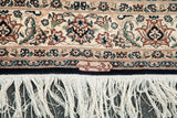 Ivory and navy border with tight floral Persian design, workshop signature, and fringe.