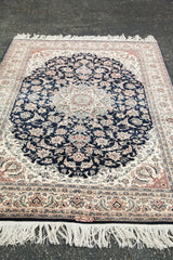 Fine detailed floral motifs and white fringe on a vintage navy Pak Persian rug.