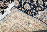 Vintage Persian design rug corner with ivory border's tight floral motifs and white fringe.