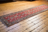Hand-knotted red Pak Kazak runner displaying geometric motifs and navy borders.