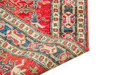Close-up of hand-knotted red Pak Caucasian runner's geometric blue and cream border.