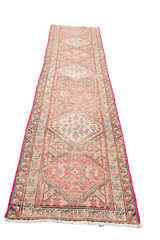 Distressed geometric pattern with bright red binding on a vintage Northwest Persian runner.