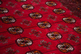 Detail of rich cranberry red field and geometric motifs on vintage Turkmen rug.