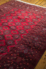 Cherry red field and intricate geometric border with stylized motifs on vintage Bokhara rug.
