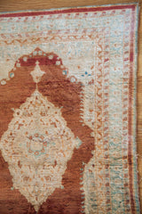 Finely knotted silk pile and time-softened wear on the corner of an antique Persian Tabriz mat.