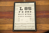 Antique eye chart plaque featuring musical notation and 1935 copyright.