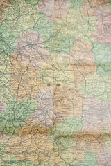 Close-up of vintage France map, showing pastel tones with visible creases and stains.