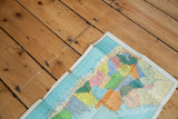 Section of vintage Argentina map, bright blue ocean, varied colored provinces, natural creases.