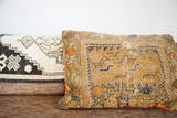 Close-up of antique orange and yellow Caucasian pillow, with geometric motifs and aged texture.