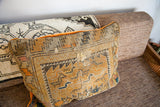 Side profile of the Antique Caucasian Pillow, highlighting its cushiony depth and orange velvet trim.