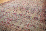 Aged cream cypress tree pattern with muted red, pink, and floral designs on antique Kerman.