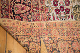 Folded corner of an antique Persian Kerman, showing aged hand-knotted pile and sturdy foundation.