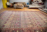 Antique Persian Kerman carpet, cypress tree motif with soft reds, beiges, and visible restorative weaving.