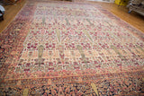 Distressed corner of an antique Persian Kerman rug, highlighting cypress trees and dark floral border.