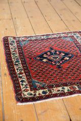 Richly colored vintage Engelas Persian mat with a bold diamond medallion, viewed from an angle.
